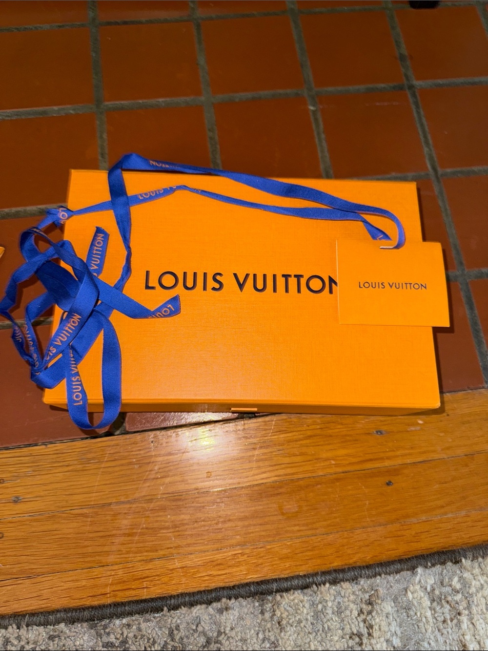 Louis Vuitton orange box with blue ribbon and tag